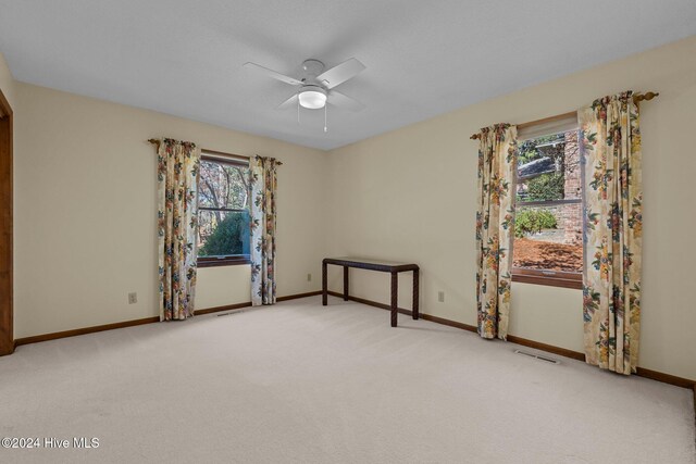 spare room featuring ceiling fan and light carpet