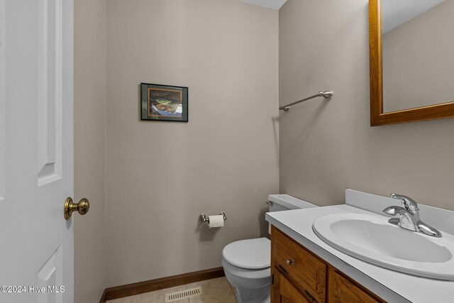 bathroom featuring vanity, a textured ceiling, toilet, and tile patterned flooring