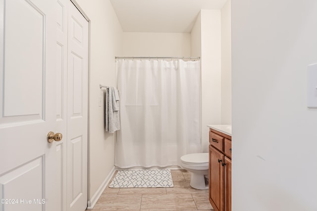 bathroom with curtained shower, vanity, and toilet