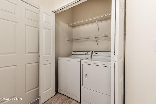 laundry room with light wood-type flooring and separate washer and dryer