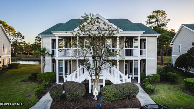 view of front of home featuring covered porch and a yard