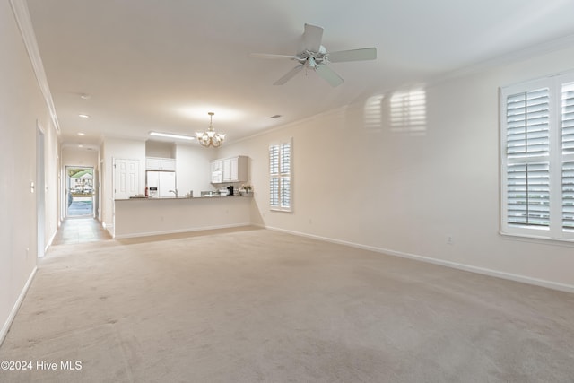 unfurnished living room featuring a wealth of natural light, crown molding, and light carpet