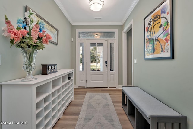 foyer entrance with crown molding and hardwood / wood-style floors