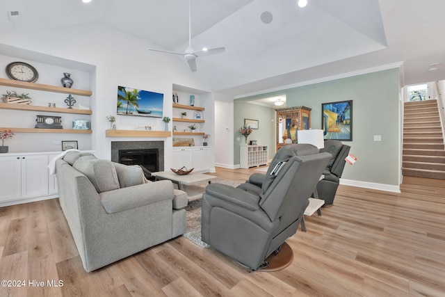 living room featuring lofted ceiling, ceiling fan, light wood-type flooring, and built in shelves