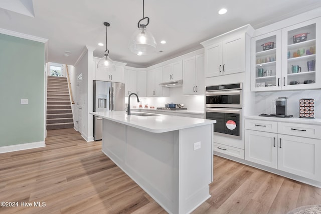 kitchen featuring stainless steel appliances, sink, pendant lighting, light hardwood / wood-style flooring, and white cabinetry