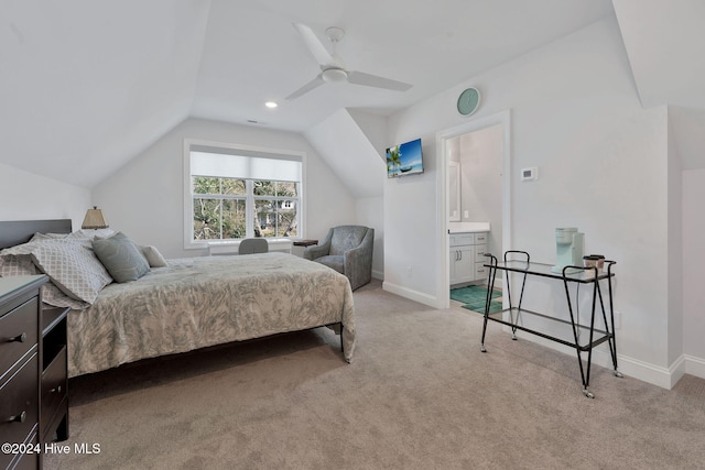 bedroom with ensuite bath, light colored carpet, vaulted ceiling, and ceiling fan