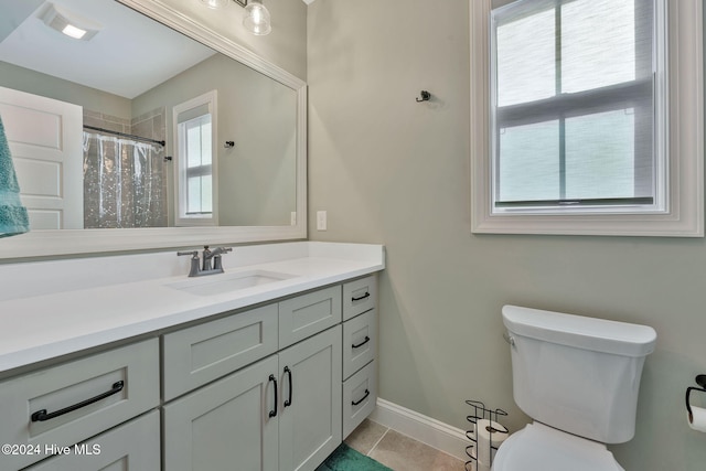 bathroom featuring tile patterned flooring, vanity, toilet, and curtained shower