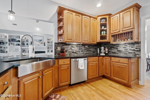 kitchen with backsplash, sink, dishwasher, and light wood-type flooring