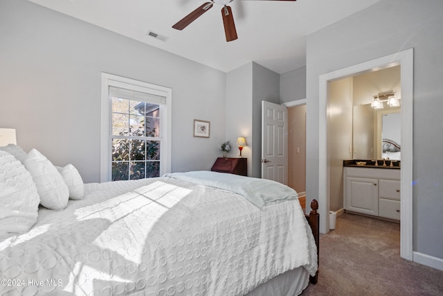 carpeted bedroom with connected bathroom, ceiling fan, and sink