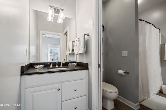 bathroom featuring vanity, curtained shower, and toilet