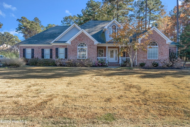 front facade with a front yard and covered porch