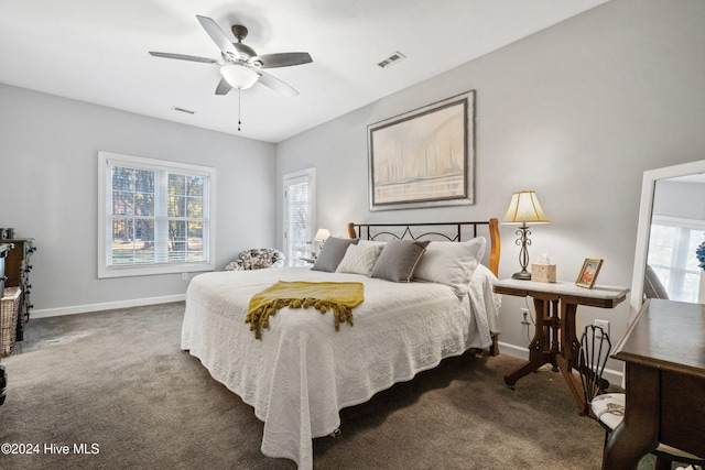 carpeted bedroom featuring ceiling fan and multiple windows