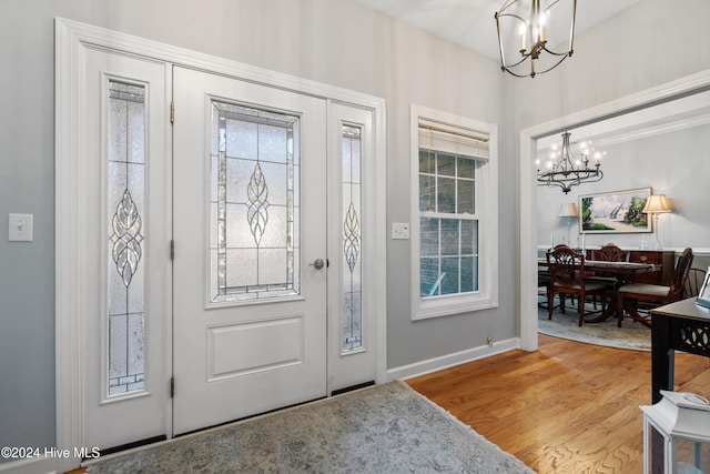 entrance foyer with wood-type flooring and an inviting chandelier