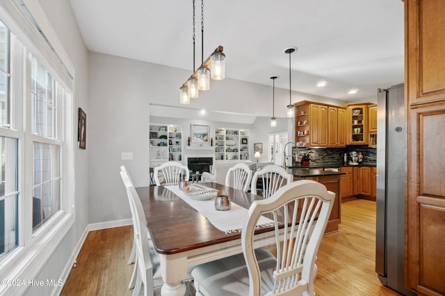 dining room featuring built in features and light wood-type flooring