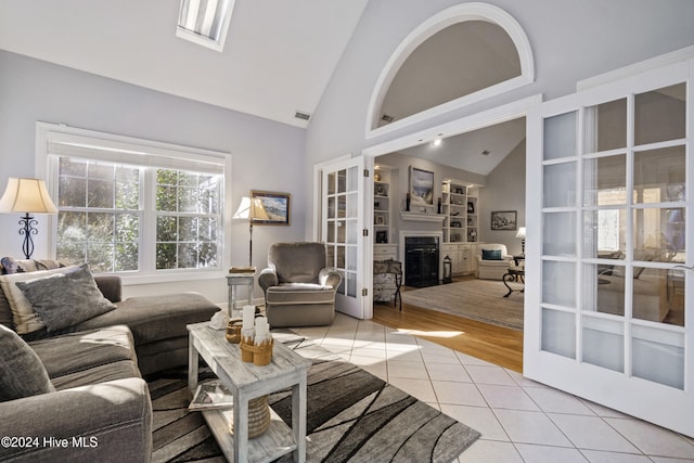 living room with french doors, light tile patterned floors, and high vaulted ceiling