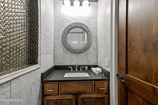 bathroom featuring vanity and tile walls