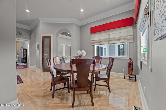 dining space featuring crown molding and light parquet flooring