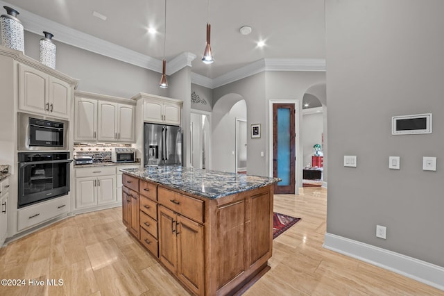 kitchen with tasteful backsplash, ornamental molding, dark stone counters, stainless steel appliances, and a kitchen island