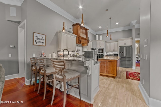 kitchen featuring hanging light fixtures, stainless steel appliances, a kitchen island, dark stone countertops, and white cabinets