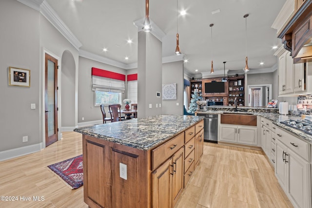 kitchen with white cabinetry, stainless steel appliances, crown molding, dark stone counters, and light hardwood / wood-style floors