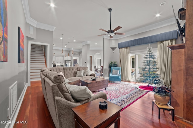 living room featuring wood-type flooring, ceiling fan, and crown molding