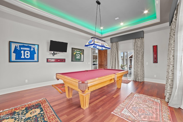 recreation room with ornamental molding, hardwood / wood-style flooring, a tray ceiling, and pool table