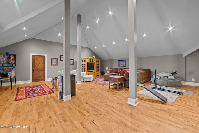 workout room with light wood-type flooring and lofted ceiling