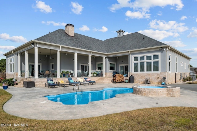 back of property featuring a patio, ceiling fan, and a pool with hot tub