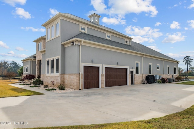 view of side of property featuring a garage and central air condition unit