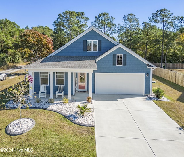 view of front facade with a garage, covered porch, and a front yard