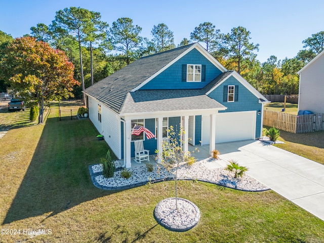 view of front of home with a front lawn, covered porch, and a garage