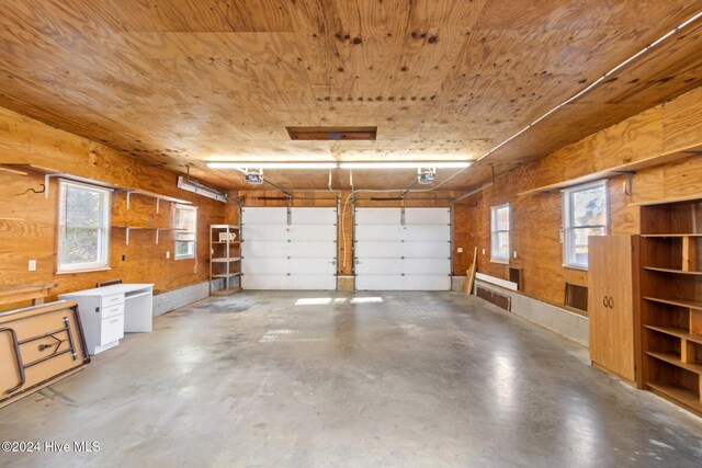 garage with wood ceiling, wooden walls, and a garage door opener