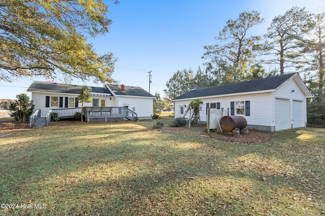 back of house with a garage, a deck, and a yard