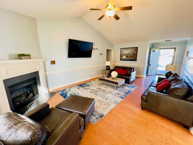 living room with lofted ceiling, ceiling fan, and wood-type flooring