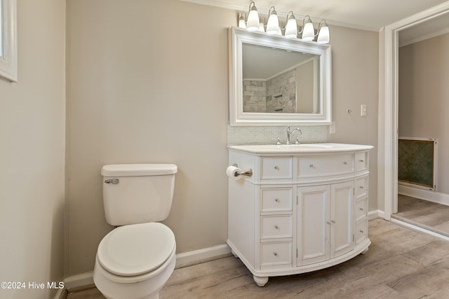 bathroom featuring hardwood / wood-style floors, vanity, backsplash, toilet, and ornamental molding