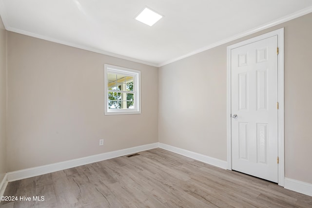 unfurnished room with light hardwood / wood-style flooring and crown molding