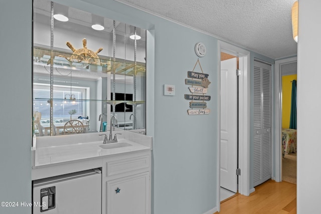 bathroom featuring vanity, a textured ceiling, and hardwood / wood-style flooring