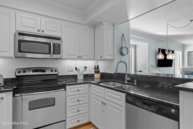 kitchen featuring sink, stainless steel appliances, a textured ceiling, white cabinets, and ornamental molding