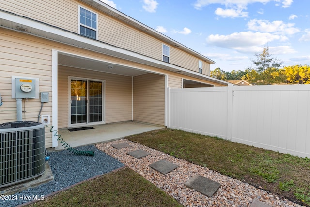 rear view of property with central air condition unit and a patio