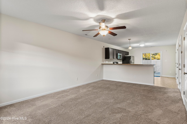 unfurnished living room featuring light carpet, ceiling fan, and a textured ceiling