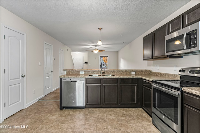 kitchen with ceiling fan, sink, stainless steel appliances, kitchen peninsula, and a textured ceiling