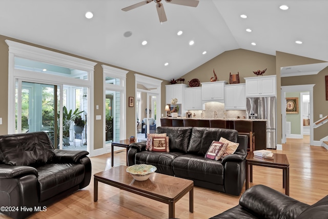 living room featuring ceiling fan, light wood-type flooring, high vaulted ceiling, and french doors