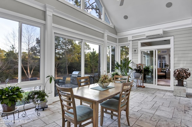 sunroom featuring a wall mounted air conditioner, ceiling fan, and lofted ceiling