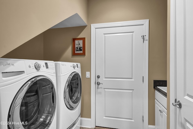 clothes washing area with cabinets and washer and clothes dryer