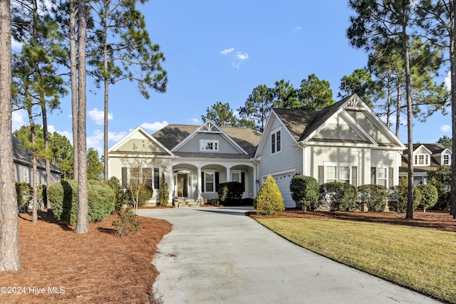 view of front of property with a front lawn, a porch, and a garage