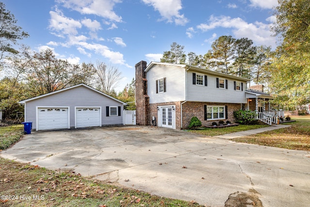 view of front of property with a garage, an outbuilding, and french doors