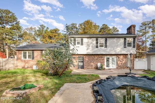 back of house with a yard and a patio