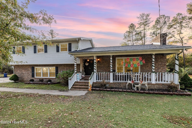 tri-level home with a porch and a yard