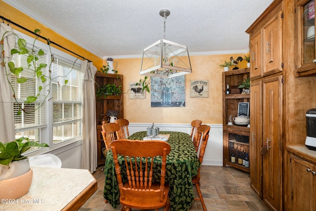 dining space featuring a textured ceiling, crown molding, and a notable chandelier