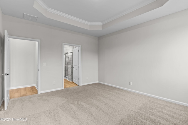 1957 Mansfield Ave SE, Bolivia, NC 28422 - unfurnished bedroom with visible vents, baseboards, a tray ceiling, crown molding, and carpet flooring